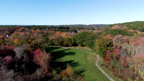 Majestic-autumn-colors-with-small-town-of-Haverhill-behind,-drone-descending-view