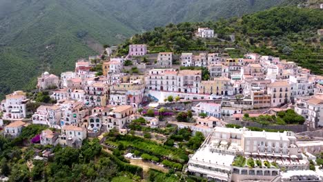 Aerial-dolly-upwards-of-an-Italian-village-in-Amalfi-coast,-revealing-the-mountains
