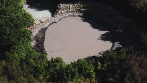 Hidden-geothermal-hot-mud-pool-surrounded-by-trees-in-New-Zealand