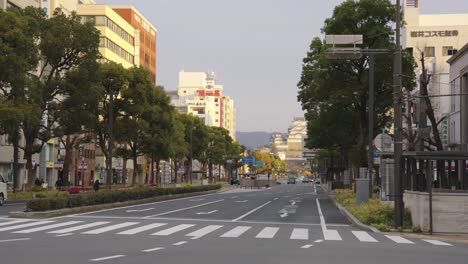 Himeji-City,-Bus-Driving-Down-Street-at-Sunrise-with-Castle-in-Distance
