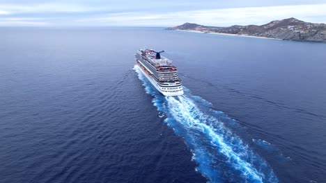Aerial-tracking,-luxury-cruise-ship-sailing-in-Cabo,-on-clear-blue-sky-day