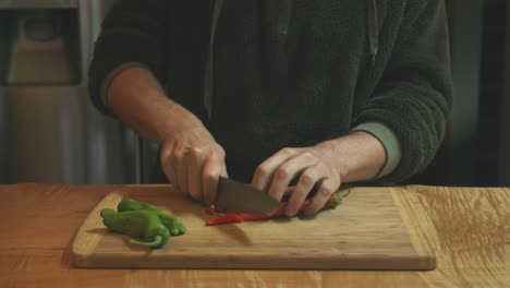 Cooker-chopping-red-and-green-hot-chili-pepper-in-the-kitchen-food-cutting-board