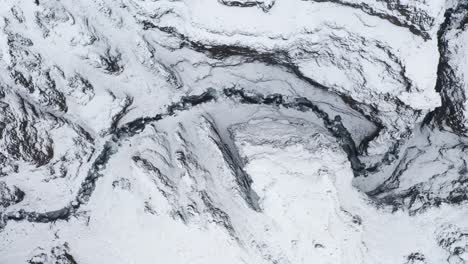 Verschneite-Schlucht-Und-Berggipfel-In-Kotargil,-Island-–-Luftaufnahme