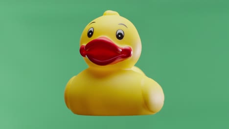 Yellow-rubber-duck-rotating-on-isolated-green-background