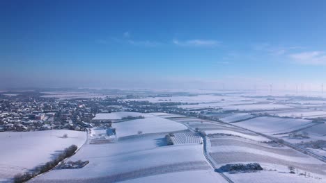 Snowy-Fields-And-Community-Near-Wind-Farm-At-Winter-In-Zistersdorf,-Lower-Austria