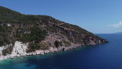 Hill-island-in-the-sea-with-blue-sky-and-water-at-Lefkada,-Greece---aerial-drone-tracking-shot