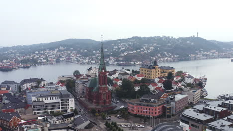 View-Over-Arendal-City-With-Houses,-Buildings-And-Parish-Church-In-Norway---aerial-drone-shot