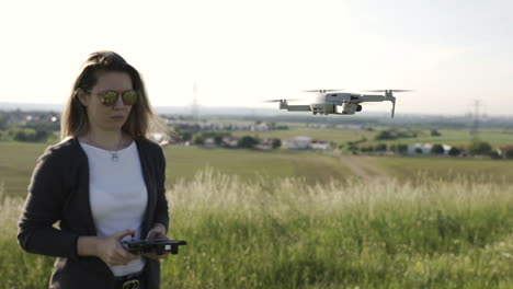 Female-With-Controller-in-Front-of-DJI-Mavic-Mini-2-Quadcopter-Drone,-Full-Frame-Slow-Motion