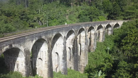 Touristen-Erkunden-Die-Architektur-Der-Neun-Bogen-Eisenbahnbrücke-In-Sri-Lanka
