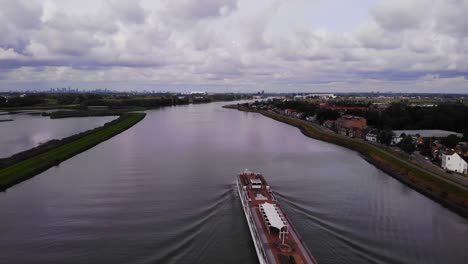 Aerial-View-Over-Deck-Of-Viking-Ve-Cruise-Longship-Navigating-Along-River-Noord-Near-Hendrik-Ido-Ambacht