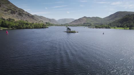 Flyover-of-an-island-on-Ullswater-lake-in-the-English-Lake-District-on-a-bright-sunny-summer-day