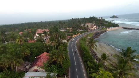 Aerial-FPV-shot-of-street-with-house-and-sea-in-the-side