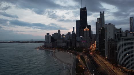 Drone-Flying-down-to-Chicago-at-sunrise-showing-the-city,-buses,-cars-and-Lake-Michigan