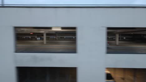 Drone-shot-of-a-car-driving-in-a-multi-storey-carpark
