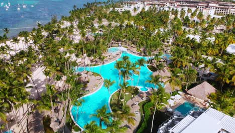 Swimming-pool-and-palmtrees-around,-aerial-drone-view-of-Bavaro-touristic-resort,-Punta-Cana,-Dominican-Republic