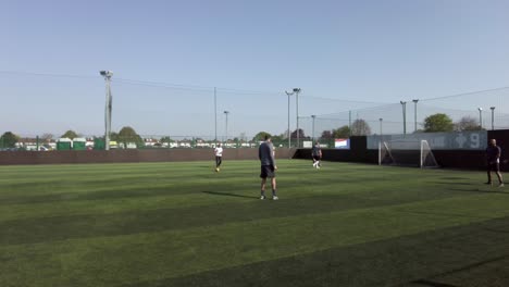 Jugadores-Calentando-Patadas-De-Fútbol-En-Goals-Ruislip-En-Un-Día-Soleado-Con-Cielos-Azules-El-24-De-Abril-De-2022