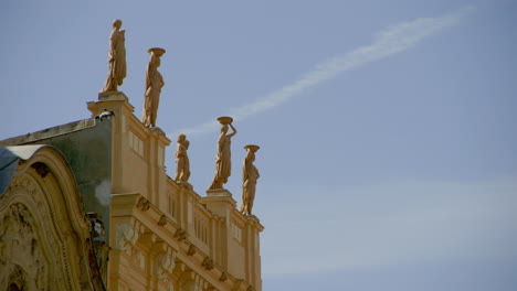 Stone-statues-stand-atop-an-old-building