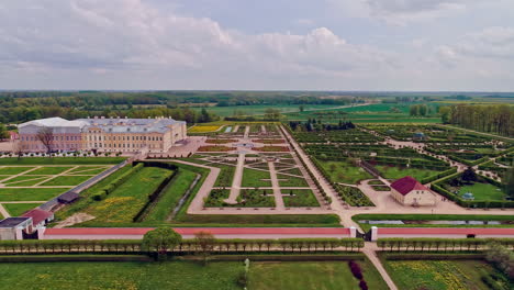 Luftaufnahme-Der-Wunderschönen-Schlossburg-Mit-Großem,-Majestätischem-Garten-Tagsüber---Parkende-Autos-Von-Besuchern,-Die-Das-Schloss-Rundale-In-Lettland-Besuchen