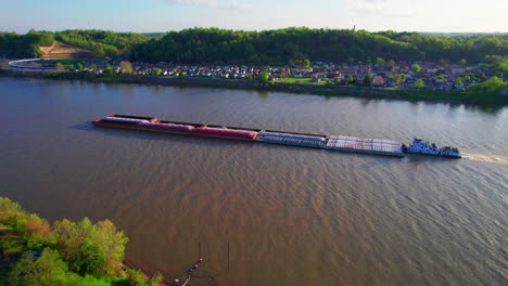 AERIAL---Pusher-boat-and-barge,-Ohio-River,-Ironton,-Ohio,-spinning-shot