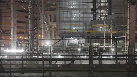 Construction-site-at-Osaka-station-at-night,-Pan-over-industrial-background