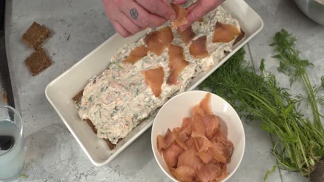 Tattooed-chef-adds-smoked-salmon-lox-to-layer-of-Smorgastarta-cake