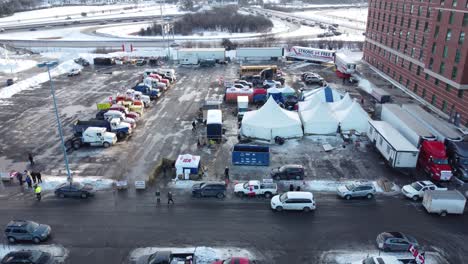 Flyover-trucks-on-Parking-lot-with-Campaign-tents-during-truckers-protest,-Freedom-Convoy