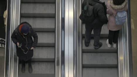 Bird's-eye-view-of-an-escalator-as-people-go-up-and-down