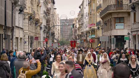A-busy-street-during-the-Fallas-festival-in-Valencia,-with-people-in-traditional-Spanish-outfits