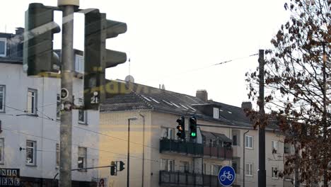 Traffic-light-in-a-German-city-behind-a-window-switching-from-green-to-red