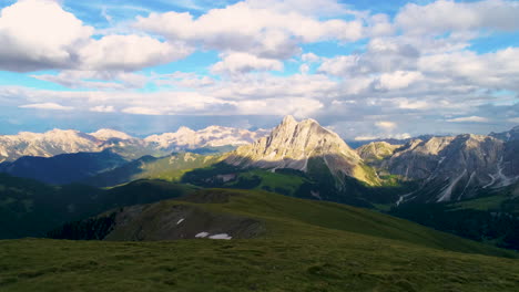 Luftaufnahme-über-Eine-üppige-Graswiese-Mit-Blick-Auf-Die-Spektakuläre,-Zerklüftete-Dolomitenlandschaft