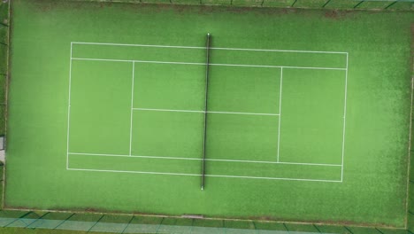 Drone-circle-zoom-out-top-shot-flying-over-tennis-court-Aerial-top-round-shot-of-tennis-court,-tennis-courts-area-in-the-green-park-zone-during-day