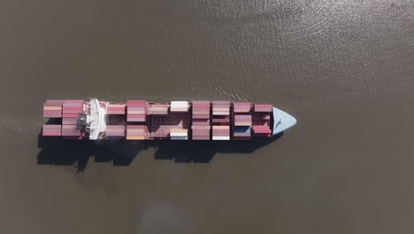 Cargo-ship-on-a-river-followed-by-2-tug-boats