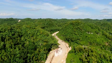Clearing-forest-landscape-to-build-new-winding-road-in-Indonesia,-aerial-view