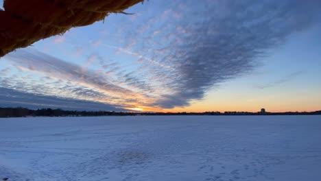 Clouds-rolling-over-a-Frozen-lake-in-Minnesota-after-sunset,-Time-lapse