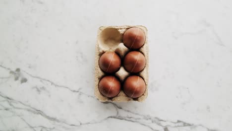 Cinematic-rotating-shot-of-golden-chocolate-Easter-eggs-on-marble-surface
