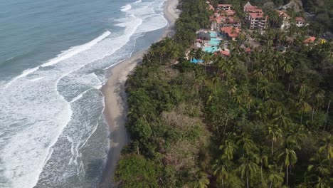 Aerial:-Resort-hotel-on-sandy-Playa-de-Mendihuaca-beach-in-Colombia