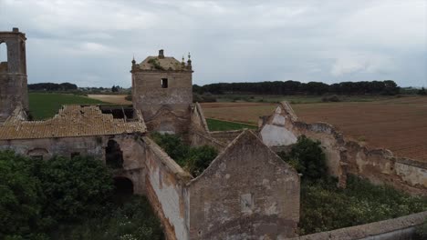 Aerial-drone-fly-over-abandoned-ruined-destroyed-farmhouse-building-in-a-field,-Spain
