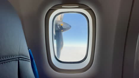 Rotating-propeller-on-a-small-airplane-in-the-air,-from-a-plane-window