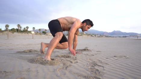 Man-doing-functional-floor-exercises-in-the-sand-on-the-beach