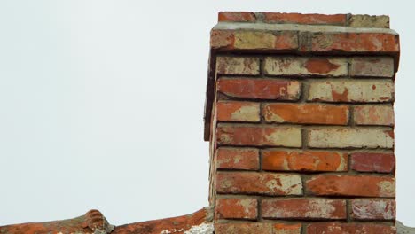 View-of-old-red-clay-brick-chimney-in-overcast-day,-medium-closeup-slow-zoom-in
