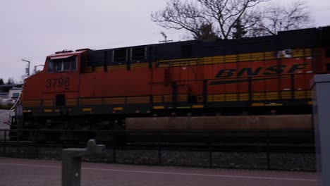 Eine-Lokomotive-Fährt-über-Einen-Fußgängerüberweg-In-Einem-Park,-In-Dem-Rote-Lichter-Blinken-Und-Menschen-Warten