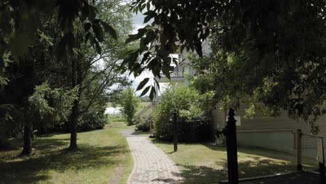 Walking-down-a-garden-path-on-a-acreage-to-reveal-a-gorgeous-mansion-guesthouse-from-behind-the-trees-at-the-Strathmere-Wedding-Centre-and-Spa