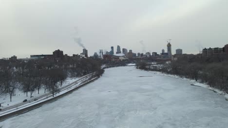Mississippi-River-completely-frozen-close-to-downtown-minneapolis-during-a-cloudy-cold-winter-afternoon-during-a-polar-vortex