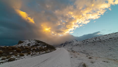Zeitraffer-Sonnenbeschienener-Wolken,-Die-über-Die-Schneebedeckte-Straße-Bei-Torres-Del-Paine-Rollen