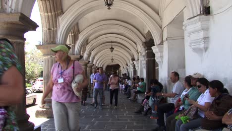 Turistas-Que-Visitan-El-Palacio-Del-Ayuntamiento-En-Antigua,-Guatemala