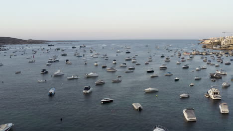 Aerial-shot-flying-over-hundreds-of-anchored-yachts-in-a-sea-bay,Malta