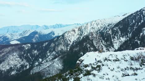 Montañas-Tatra-Con-Un-Tipo-Parado-En-Un-Acantilado-Blanco,-Vista-Panorámica,-Antena