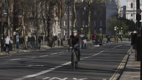 Blick-Auf-Radfahrer,-Die-Entlang-Der-Leeren-Millbank-Road-In-London-Fahren