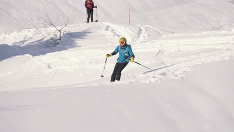 Agile-skier-slides-downhill-and-jumps-before-landing-in-snow