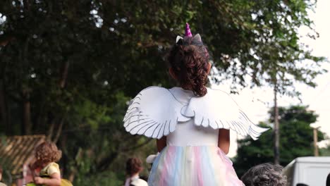 young-girl-with-long-brown-hair-from-behind-with-white-dress,-wings-and-a-unicorn-horn